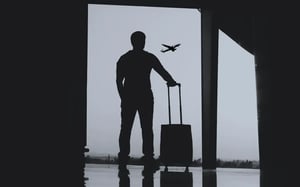 man waiting for a plane with luggage