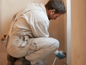 Profissional com uniforme de manutenção realizando trabalho de emergência, simbolizando despesas inesperadas em viagens ou eventos.